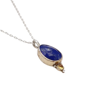 a pendant with a deep blue faceted lapis lazuli with golden flecks. Bezel set in Sterling and accentuated with a regal pop of color compliments of a golden citrine.