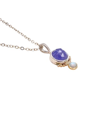 a pendant with a lavender-hued, faceted tanzanite stone is bezel set in Sterling. Accentuated with a series of 14k gold beads and an opal bezel set in gold.