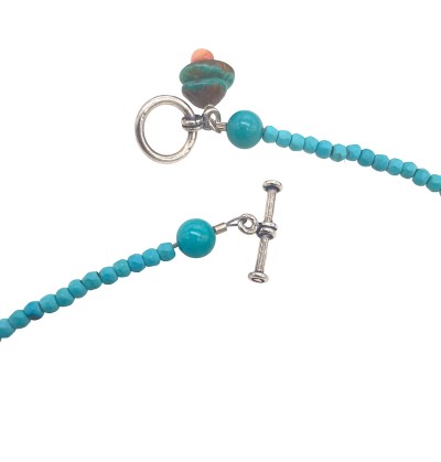 a strung bead necklace of turquoise beads and small silver beads with a toggle clasp.