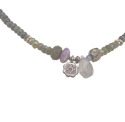 a necklace of strung mossy-hued polished round beads with small silver charms and a toggle clasp.