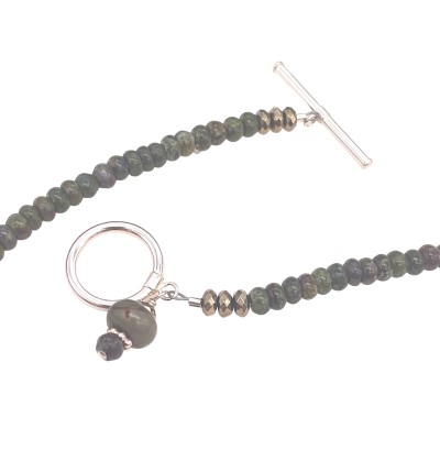 a necklace of strung mossy-hued polished round beads with small silver charms and a toggle clasp.