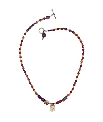 a necklace of strung desert-hued polished round beads with small silver charms and a toggle clasp.