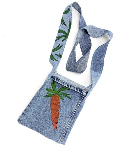 a handsewn shoulder bag of blue jean material with a painted illustration of an orange carrot with green leafy top.