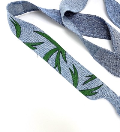 a detail of the strap with green leafy designs.