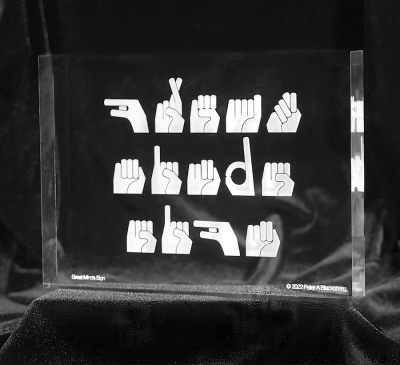 a clear acrylic block with 'great minds sign' in ASL.