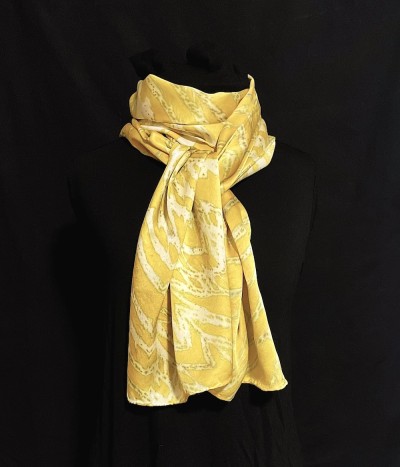 a silk scarf with a striations of colors including chartreuse yellow and white.