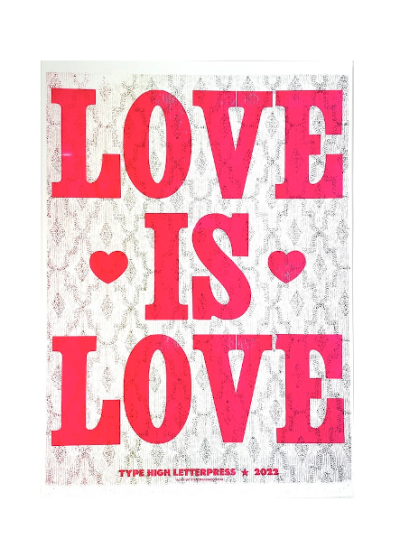 a letterpress print with the words 'Love is Love' in bold bright pink on a patterned background.