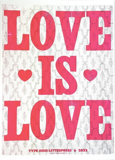 a letterpress print with the words 'Love is Love' in bold bright pink on a patterned background.
