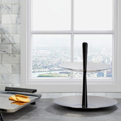 a sleek modern stainless steel two-tiered serving dish with a central black core that emerges from the top as a handle pictured in a kitchen setting