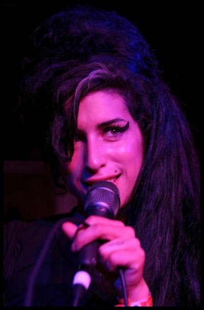 a color headshot photograph of musician Amy Winehouse.