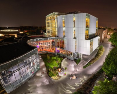 a night time image of the glass and steel building on the RIT campus called 'The Shed'