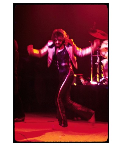 a color photograph of musician Peter Wolf dancing on stage.