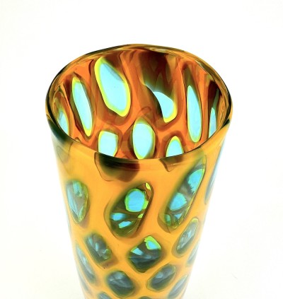 a tall narrow handblown glass conical shaped vase with a gold colored body and clear glass ovals outlined in turquoise.