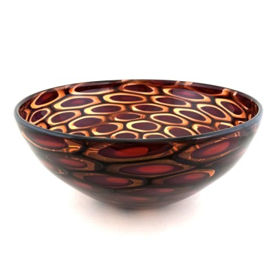 a handblown glass bowl with a full coverage murrain pattern of red ovals with a golden outline all embedded in a burgundy background.