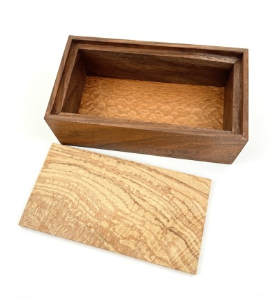 a handmade rectangular walnut box with a light applewood lid.