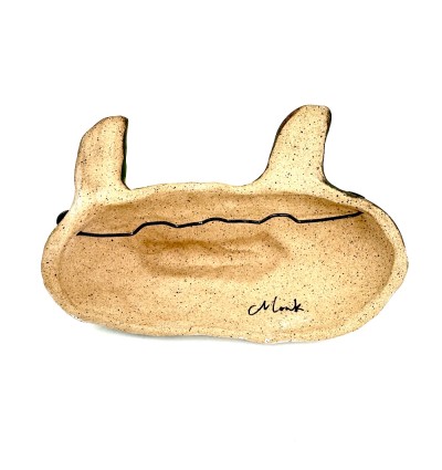 the backside of a hand sculpted ceramic mask form.