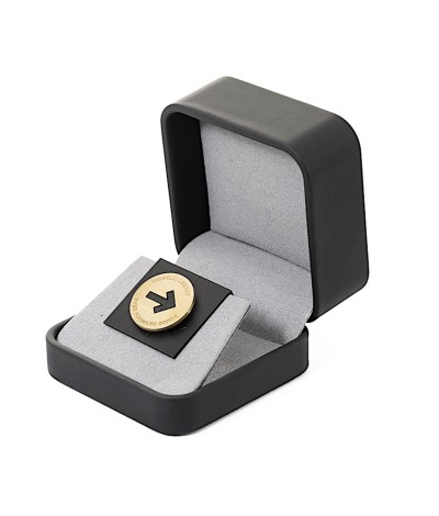 a small round brass token in a presentation box.