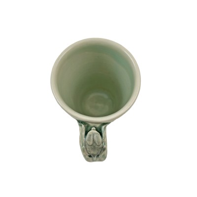 Top view of soft green glazed mug adorned with a small bat