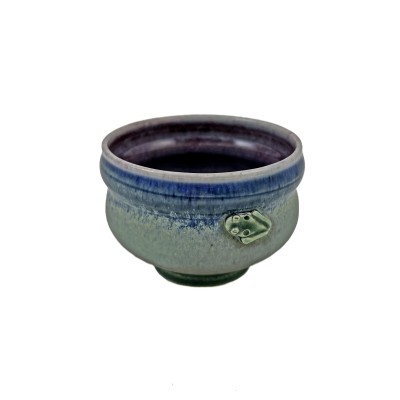 Yunomi teacup with green and blue hue glazes, adorned with a tiny frog on the side, and deep purple glazed interior