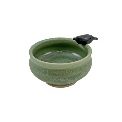Small light green bowl with a small black crow on the rim