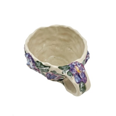 Top view of hand formed mug with textured purple flowers and painted cats