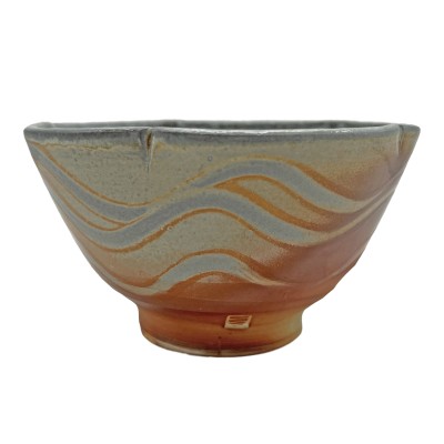 side view of a scalloped-edge bowl with wave patterns in orange and light grey