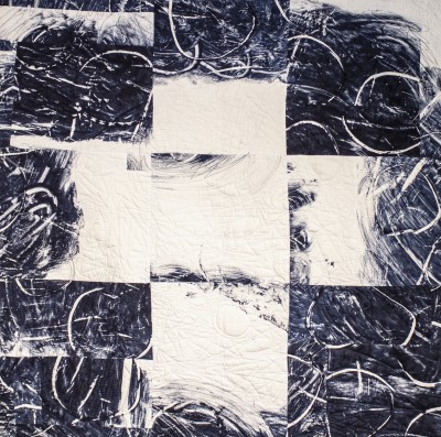 an abstract quilt with a dark blue and white palette