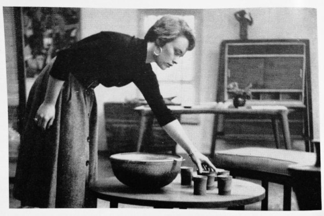 Woman placing ceramic cups on a table