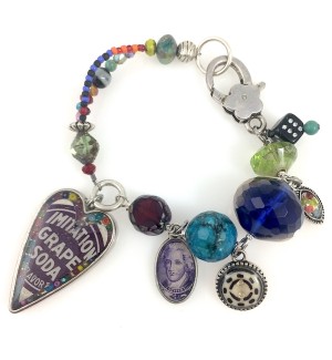 A multi colored charm bracelet with eclectic charms, one charm is a large Purple Heart.