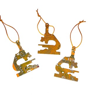 Three yellow microscope shaped ornaments made of circuit board hung with yellow string.