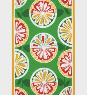 A table runner with a green background and yellow border, there are graphic representations of citrus fruit arranged in columns in shades of red, green, and yellow.
