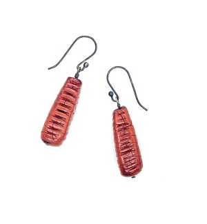 A pair of red cylindrical earrings with notches on 4 sides.