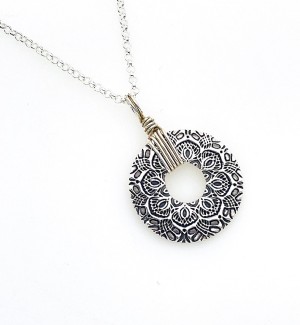 donut shaped Sterling Silver Pendant with Mandala pattern on it with wire wrapped bail.