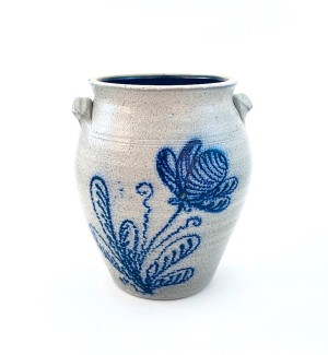 A white ceramic jar with a blue illustration of a flower and leaves on the front.