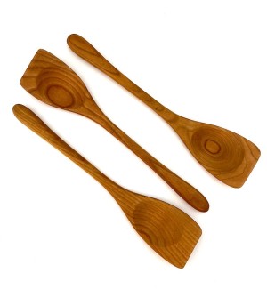 Three wooden spoons with flat edges.