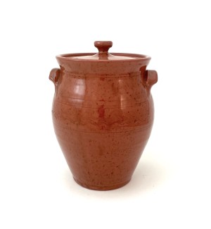 A lidded red ware jar with small handles on either side and a decorative finial on the lid.
