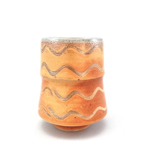 Ceramic tiered cup with wavy patterns of white on orange with a pale gray accent tone on the rim, bottom, and inside.
