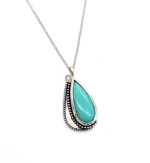 A necklace with a teardrop shaped turquoise gemstone.