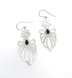 A pair of silver earrings with a filigree pattern with a black oval shaped gemstone at the center of each earring.