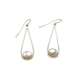 A pair of silver earrings with an open teardrop shape, at the bottom of the teardrop sits a white oval shaped gemstone.
