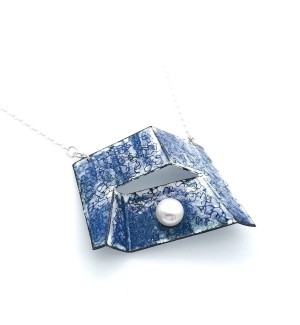 blue enamel coated folded plane of copper with an angular fissure opening and pearl set on it with silver chain attached to pendant.
