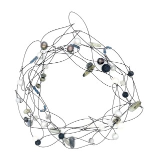 a variety of faceted beads, shells, naturally tumbled glass, and semi precious stones on a black coated wire necklace.