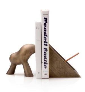 cast bronze Bookends with one in an abstract organic shape and the other a triangular prism with a pencil holder in the center with two books in between them.