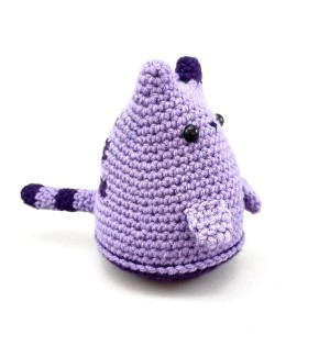 A cone shaped crocheted purple tiger toy.