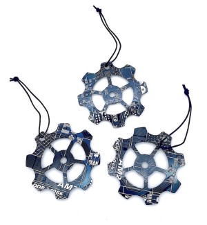 Three blue gear shaped ornaments made of cut circuit board hung on a black string.