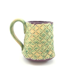 Handbuilt tan and pale green Ceramic Mug stamped with decorative pattern with purple inside.