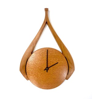 Wooden stippled round clock face with different toned swooshing decorative element.
