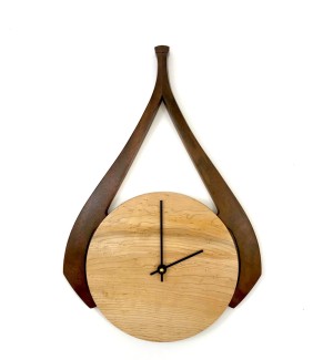 Wooden light round clock face with dark swooshing decorative element.