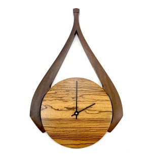 Wooden striped round clock face with darker swooshing decorative element.