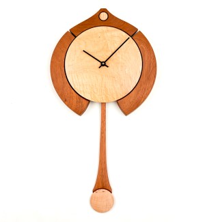 Wooden light round clock face with different toned decorative framing and long swooping pendulum.